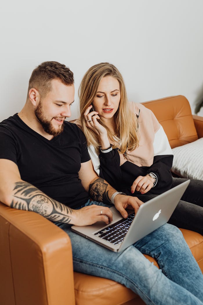Young couple enjoying time together on sofa using a laptop.